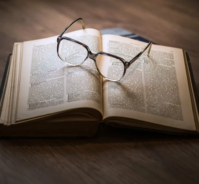 Glasses sitting on top of an open book.